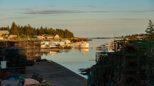 A scenic shot of a Maine harbor with boats and lobster traps on a dock