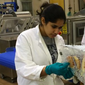 Portrait of Dhriti Nayyar working with scallops in a laboratory