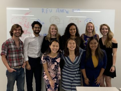 group of graduate students standing in front of white board